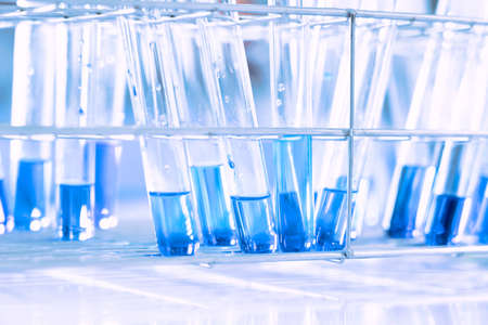 glass flask in chemical science education laboratory with molecular structure in blue backgroundの写真素材