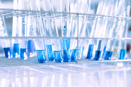 glass flask in chemical science education laboratory with molecular structure in blue backgroundの写真素材