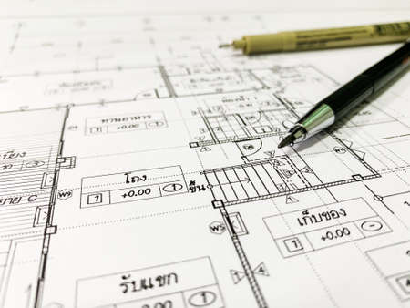 Architectural blueprints and a drawing instruments on the worktable.Selective Focus