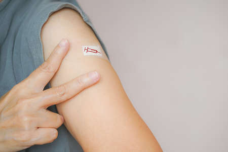 senior woman show two fingers, victory sign, after vaccination, population, social or herd immunity ,immunization vaccine health conceptの写真素材