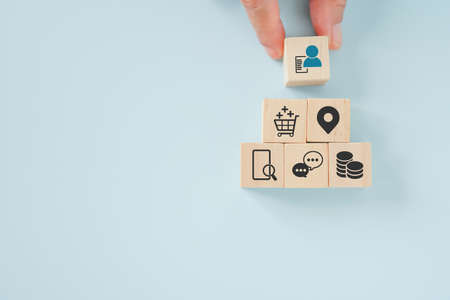 senior's hand holding wooden cubes with person with data icon on  for buyer persona and target...