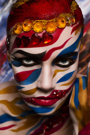 Portrait of a woman with a painted face. Creative makeup and bright style.の写真素材
