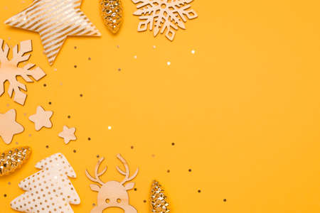 Beautiful Christmas background with glass, textile, wooden decorations on yellow background with...