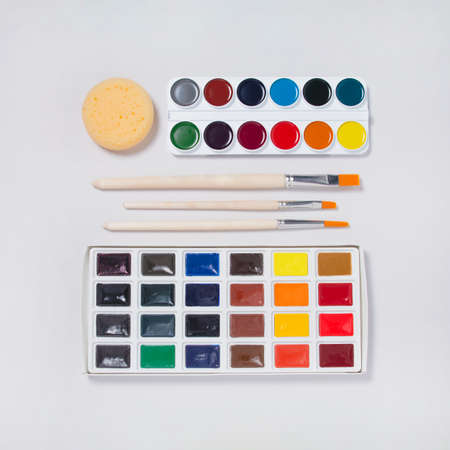 Artistic set for painting wih new watercolor paints, tools and brushes on white background. Artist...