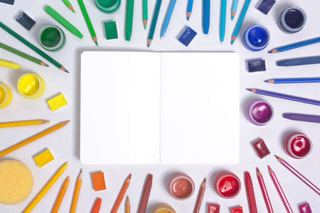 Artist workspace with watercolor, gouache, acrylic, pencils, pastel, brush, sketchbook and chalks. Art workplace consept. Flat lay with copy spaceの写真素材