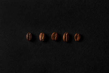 Five different types of coffee beans. Fresh roasted coffee beans closeup on black stone background. Top view, flat lay with copy spaceの写真素材