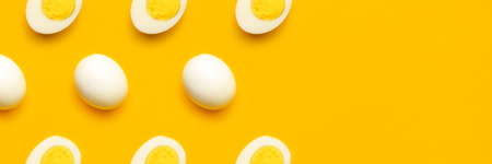 Banner with fresh chicken boiled half cut eggs pattern on yellow background. Healthy food or Happy...
