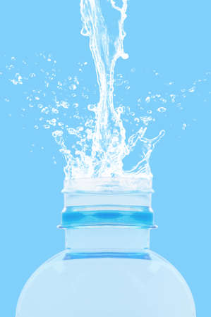 Water splash on bottle, freshness concept on blue background
