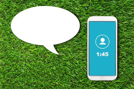 Communication concept, mobile phone and bubble chat on green grass background