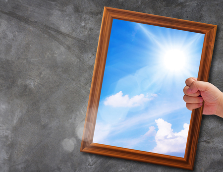 Business solution, problem concept, hand holding wooden frame way out to blue sky backgroundの写真素材