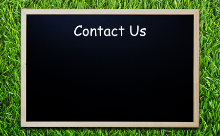 Website and internet contact us concept, customer service, blackboard on green grass background,...