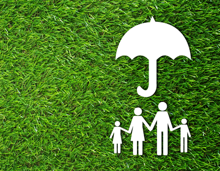Insurance concept, security life, family paper on green grass backgroundの写真素材