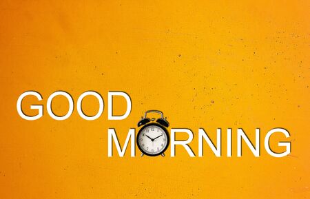 Good morning and wake up concept, retro alarm clock on yellow vintage background
