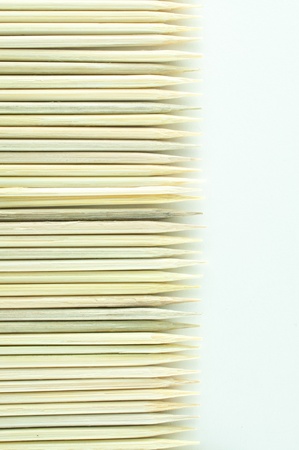 Multiple wooden bamboo skewers laying on white backgroundの写真素材