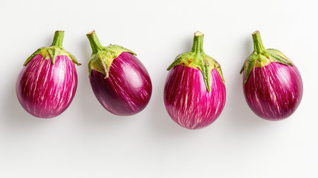 Minimal food photography of four eggplants, smooth texture and vibrant color on whiteの素材