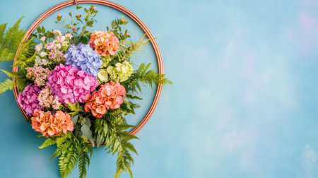 A beautiful and vibrant floral arrangement featuring hydrangeas and ferns displayed against a soothing blue background. Ideal for home decor ideas and wedding inspirations.の素材