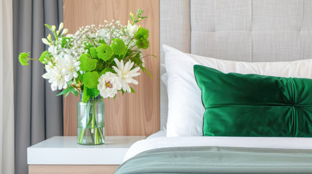 This elegant bedroom features a plush bed adorned with a stylish decorative pillow and a fresh floral arrangement in a glass vase, offering a harmonious blend of comfort and style.の素材