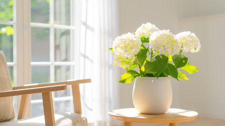 A bright indoor setting featuring a beautiful white hydrangea arrangement in a simple vase on a wooden table, creating a serene atmosphere.の素材