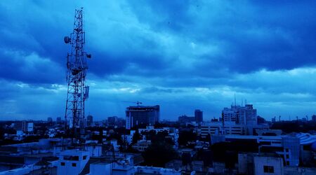 Filter Coloured Blue sky with telecommunication tower and city Ariel view