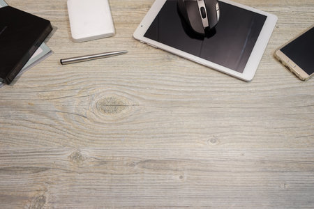 Copyspace of smart phone tablet and computer devices pen with wood top tableの写真素材
