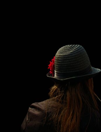 Young woman with hat isolated on black surface の写真素材