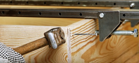 Working carpenter with old good hammer 