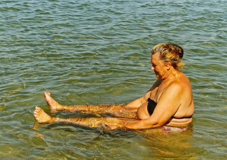 Grandmother is healing  in the salt water of Moinaki salt lake.の写真素材