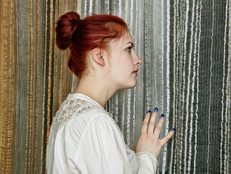 Portrait of a beautiful woman at the window. の写真素材