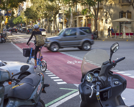 BARCELONA, SPAIN - SEPTEMBER 19, 2014. Young woman ride a bike on a road in Barcelona on 19.09....