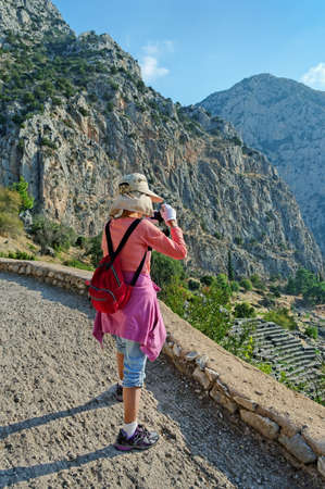 Woman looks at the ruins of the ancient theater of Delphi in Greece.の写真素材