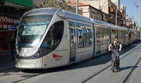 ISRAEL, JERUSALEM - OCTOBER 30: Jerusalem is one of the oldest cities in the world. Bicyclist and a modern tram goes along the street of Jerusalem on 30 October 2016.のeditorial素材