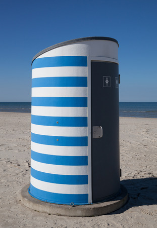 Striped small toilet on a beach.の写真素材