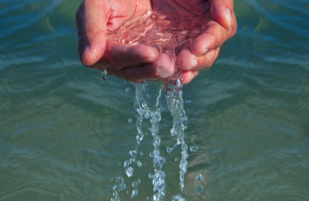Photo of hands with sea water.の写真素材