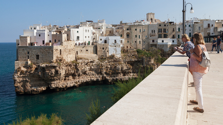 ITALY, POLIGNANO A MARE - OCTOBER 3: Polignano a Mare is a town located on the Adriatic Sea. People walking on the Mediterranean sea promenade at the city beach, 3 October 2017, Polignano a Mare, Italy.のeditorial素材