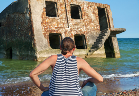 Man sailor on background of broken house on ocean.の写真素材