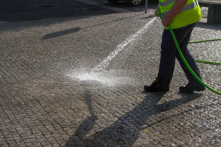 Wet cleaning of street with pressurized water.の写真素材