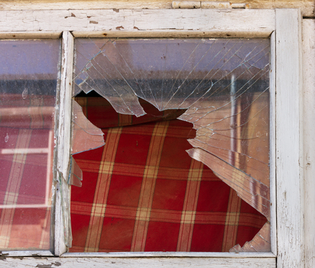 Glass window with old wooden frame on wall damaged house.の写真素材