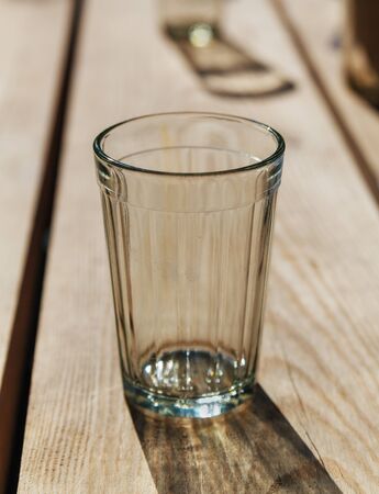 Empty glass on a natural wooden table.の写真素材
