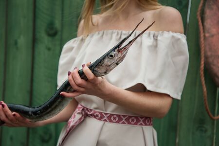 Fisherwoman with garfish in her hands.の写真素材