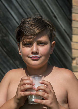 Boy drinking milk from glass.の写真素材