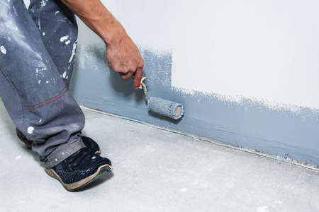 Painter man with roller renovate of wall.の写真素材