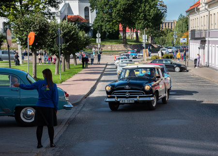 LATVIA, SALDUS - 19 SEPTEMBER: Saldus is a Latvian town. Along the city runs the RigaâLiepÄja highway. View to the street with old fashioned cars parade on 19 September 2020, Saldus, Latvia.のeditorial素材