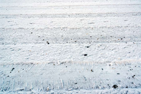 Surface of snowy road with weel tracks.