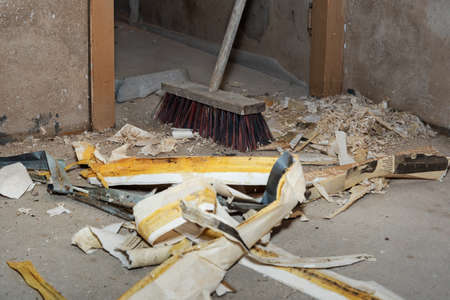 Garbage and broom inside of house in repair time.