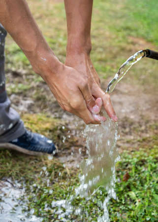 Man washing hands outdoor in countryside.
