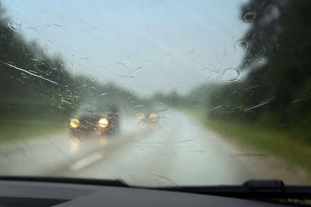 View to road through car window in rainy day.
