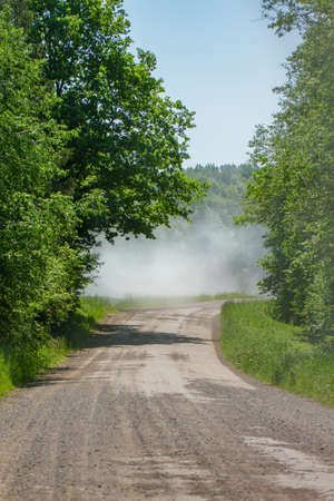 Landscape of a dusty country road on a sunny summer day.の写真素材