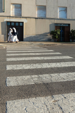 Street view in a small town with nuns.の写真素材
