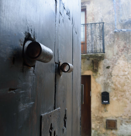 The opened big heavy door to the narrow street.の写真素材