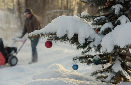 A man works with a snowplow during Christmas.の写真素材